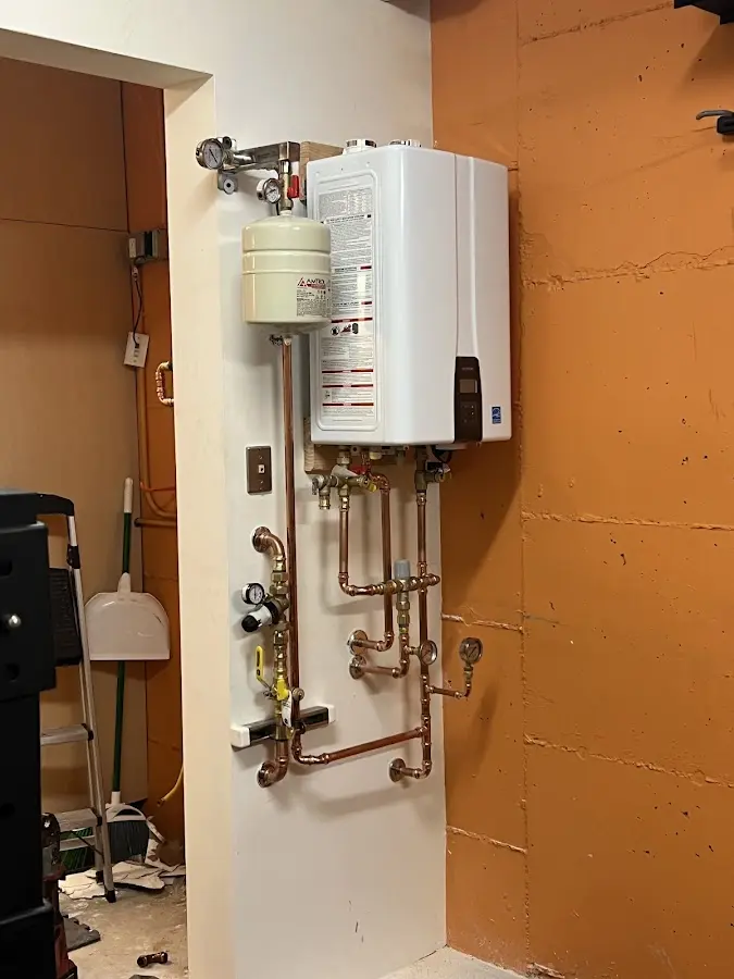 Plumbing technician inspecting water heater connections in Boulevard Park